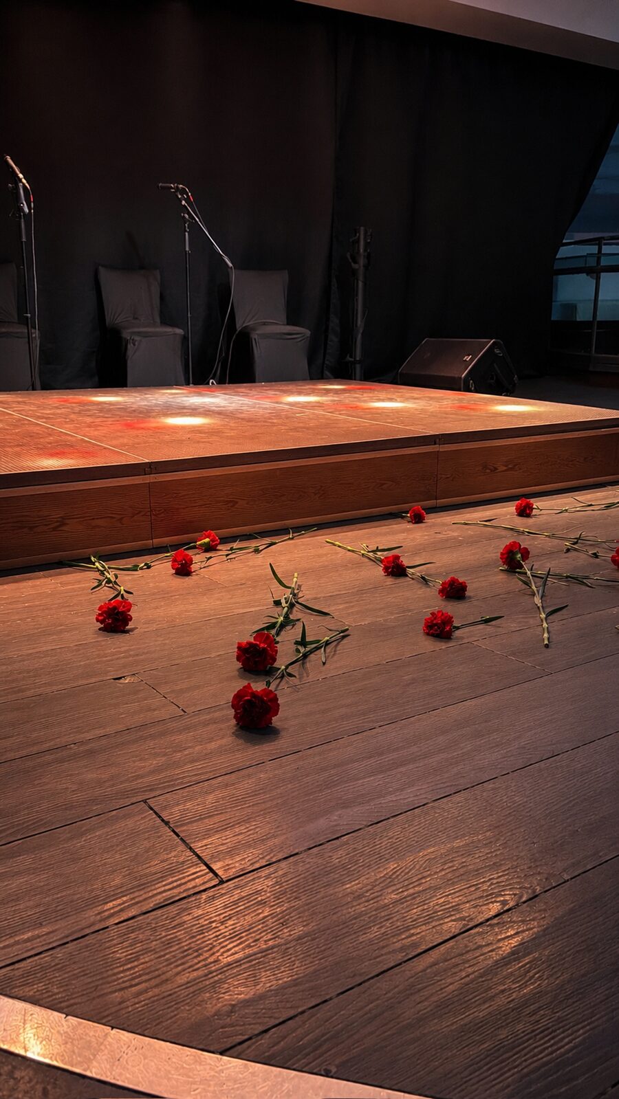 Escenario del tablao con claveles rojos sobre la madera — Flamenco & Events Barcelona